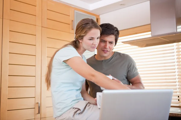 Woman pointing at laptop screen by man — Stock Photo, Image