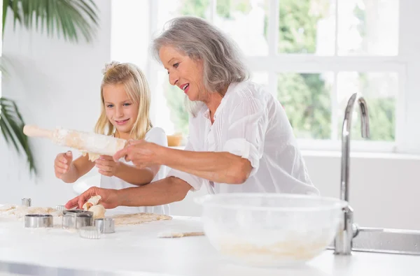 Grandmother and granddaughter using a rolling pin — Stock Photo, Image