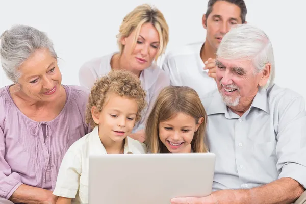 Famiglia gioiosa che guarda uno schermo di computer portatile insieme — Foto Stock
