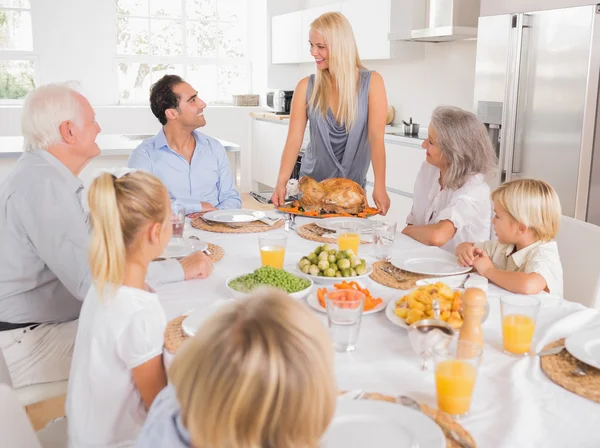 Family looking at the mother with a turkey plate — Stock Photo, Image