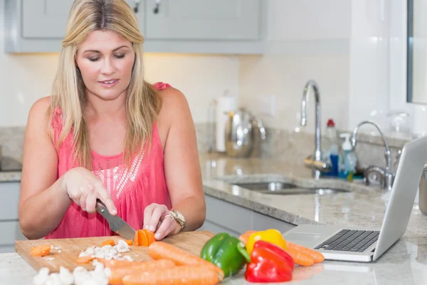 Femme faisant recette à partir d'Internet sur ordinateur portable dans la cuisine — Photo