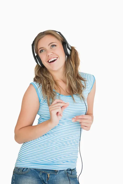 Ung kvinna njuter av musik över hörlurar — Stockfoto