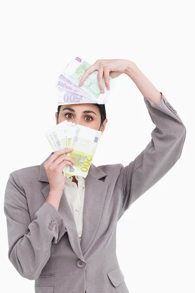 Business woman holding fanned banknotes over face — Stock Photo, Image