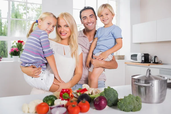 Children in their parents arms in the kitchen — Stock Photo, Image