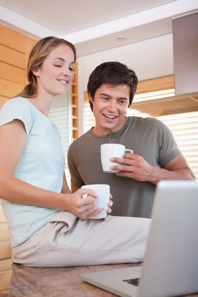 Casal usando laptop enquanto bebe café — Fotografia de Stock