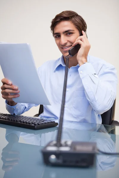 Business man holding document while on call — Stock Photo, Image