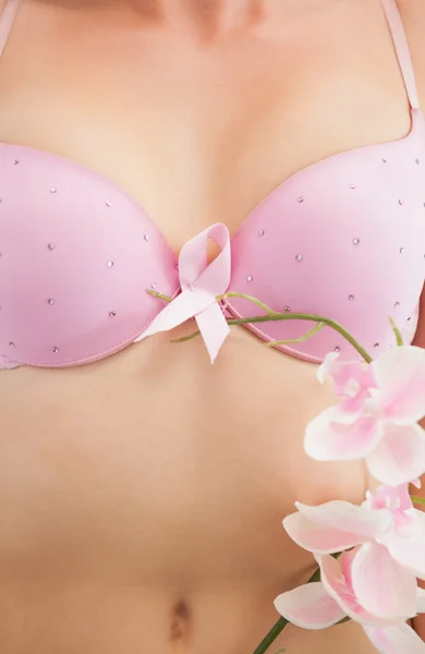 Femme avec ruban de sensibilisation au cancer du sein et fleur — Photo