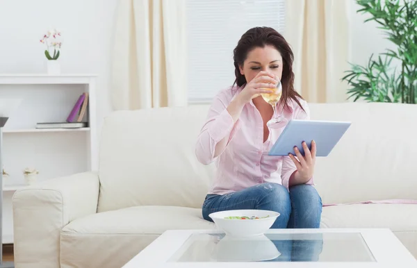 Frau trinkt Wein mit digitalem Tablet zu Hause — Stockfoto