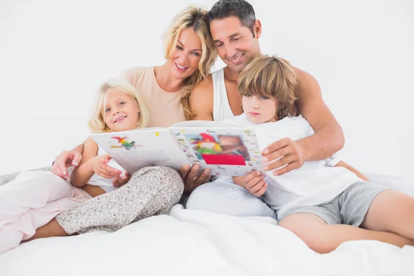 Sorrindo família lendo uma história juntos — Fotografia de Stock