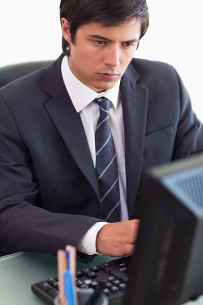 Jovem empresário sério usando computador — Fotografia de Stock