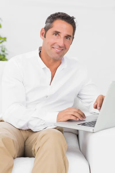 Homem alegre digitando no laptop — Fotografia de Stock
