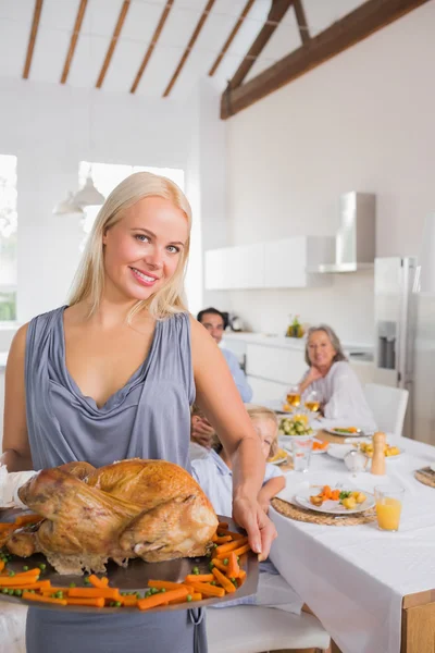 Lächelnde blonde Frau zeigt den Truthahnbraten — Stockfoto