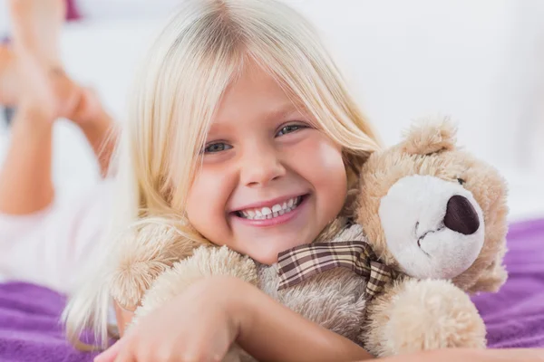 Blondes Mädchen umarmt ihren Teddybär — Stockfoto