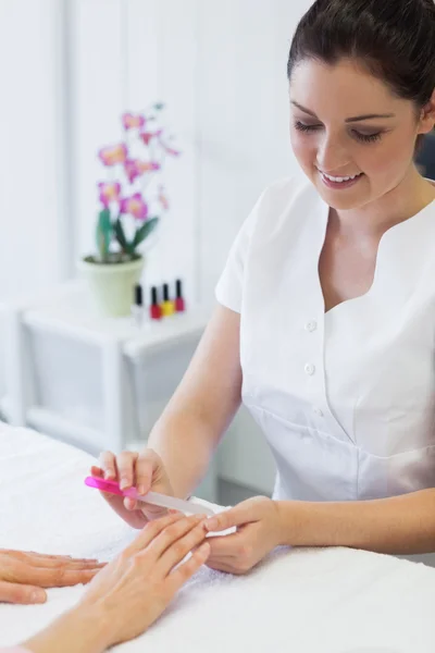 Manicurist filing woman's nails — Stock Photo, Image