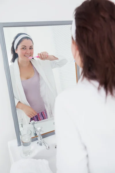 Femme se brossant les dents dans le miroir — Photo