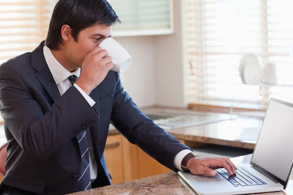 Business man using laptop while drinking coffee — Stock Photo, Image