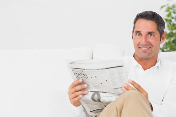 Smiling man reading a newspaper — Stock Photo, Image