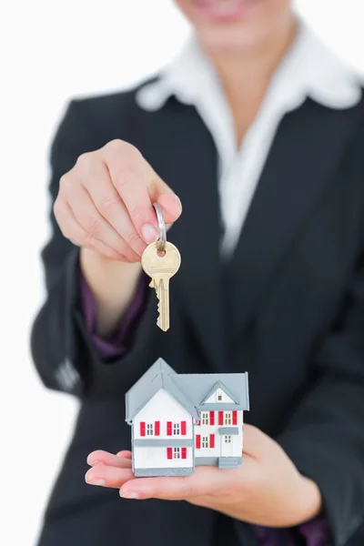 Real estate agent with house model and keys — Stock Photo, Image