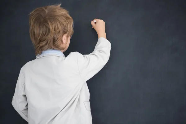 Boy dressed as teacher writes on black board — Stock Photo, Image