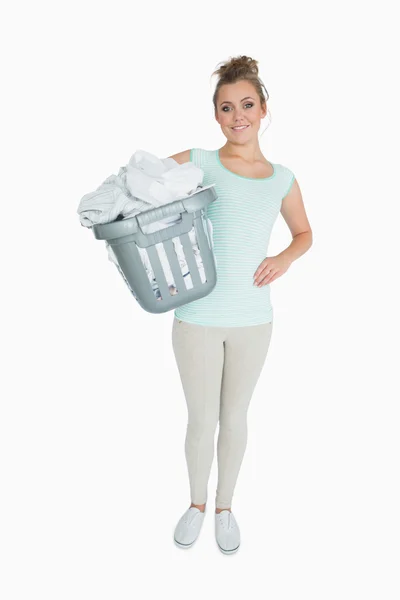 Portrait of young woman carrying laundry basket — Stock Photo, Image