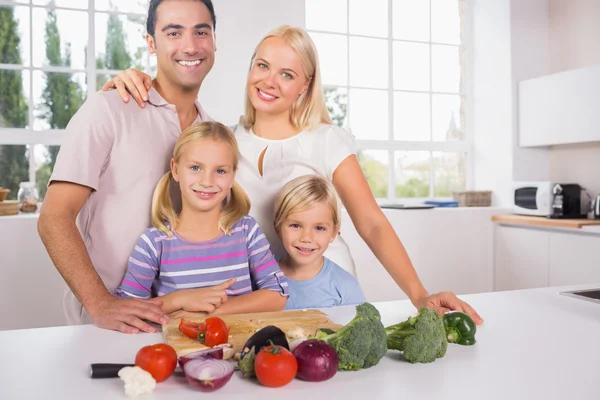 Sorridente posa famiglia tagliare verdure insieme — Foto Stock