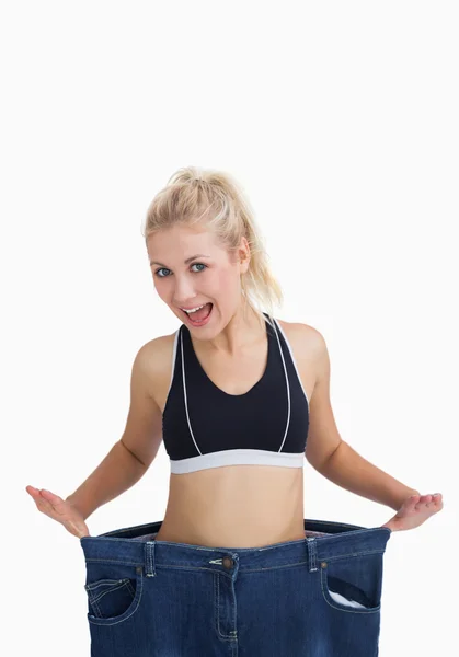 Thin woman wearing old pants after losing weight — Stock Photo, Image