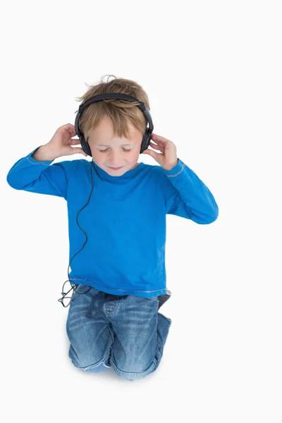 Menino ouvindo música através de fones de ouvido — Fotografia de Stock