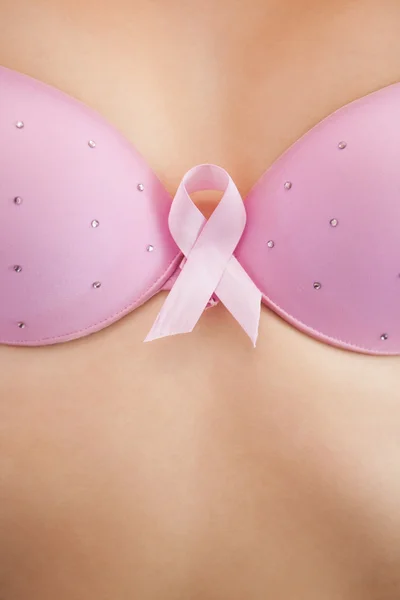 Kvinna i behå med breast cancer awareness ribbon — Stockfoto