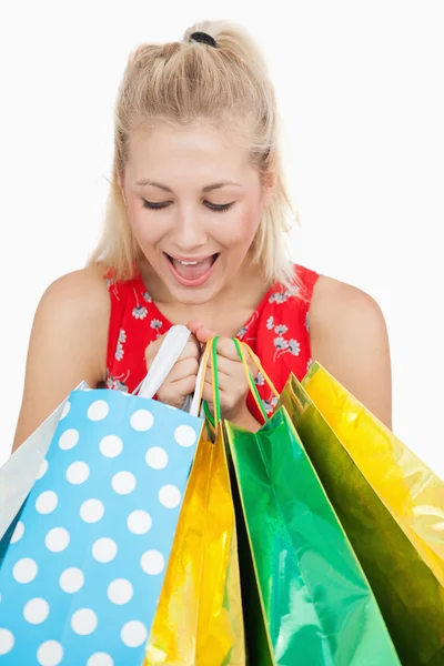 Linda mujer emocionada mirando en sus bolsas de compras —  Fotos de Stock