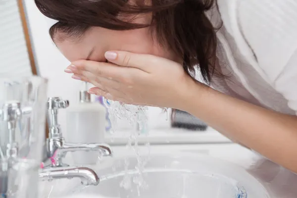 Nahaufnahme einer Frau, die sich das Gesicht wäscht — Stockfoto