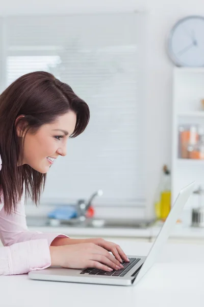 Seitenansicht einer glücklichen Frau mit Laptop — Stockfoto