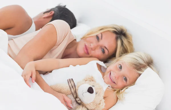 Familie liegt zusammen auf einem Bett — Stockfoto