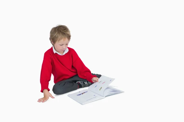 Mały chłopiec siedzi i czytanie książki — Zdjęcie stockowe