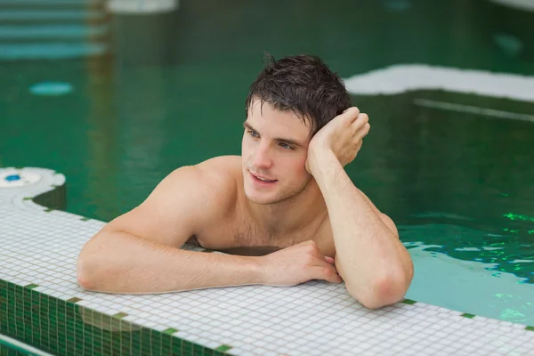 笑みを浮かべて男はプールでリラックス — ストック写真