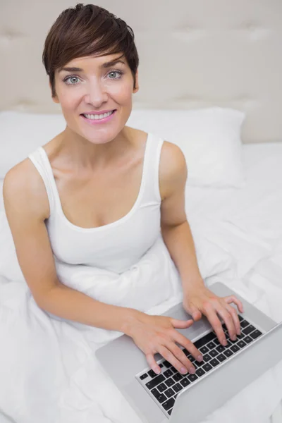 Woman looking up from laptop — Stock Photo, Image