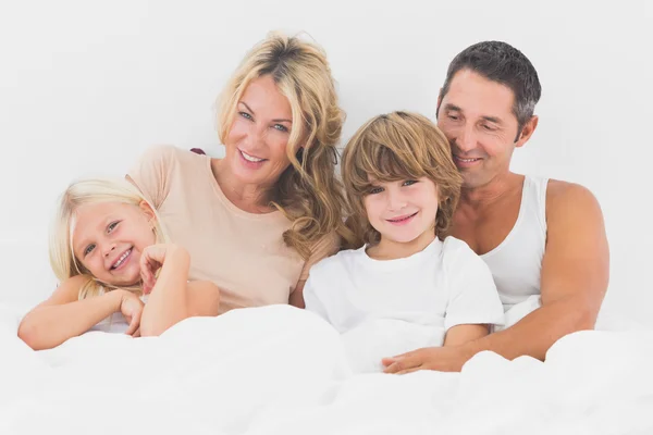 Familjen liggande på en vit säng — Stockfoto