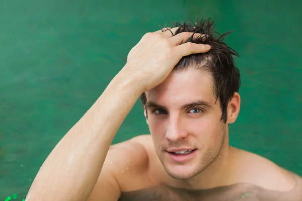 Man touching his hair in the swimming pool — Stock Photo, Image