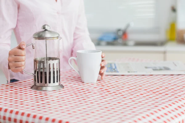 Mulher com chaleira e xícara de café — Fotografia de Stock