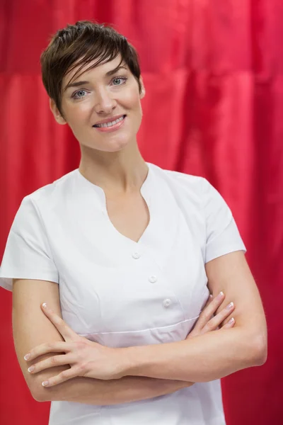 Kapper met gekruiste tegen rode gordijn armen — Stockfoto