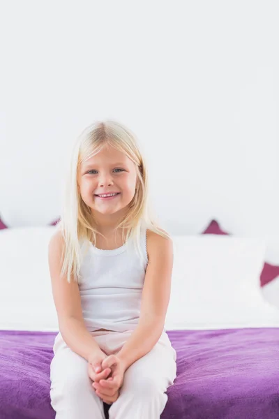 Kleines Mädchen sitzt auf einem Doppelbett — Stockfoto
