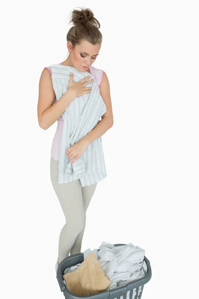 Camisa plegable mujer joven con cesta de lavandería — Foto de Stock