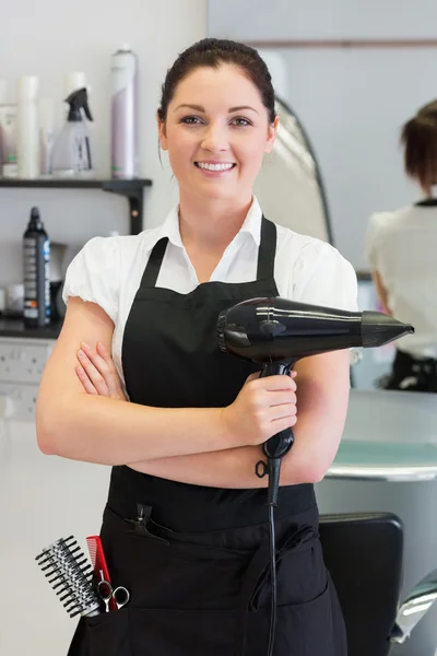 Cabeleireiro feminino confiante segurando secador de cabelo — Fotografia de Stock