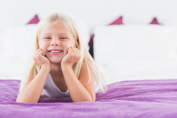 Klein meisje liggend op een tweepersoonsbed — Stockfoto