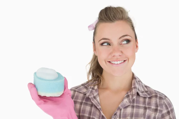 Smiling woman holding soap suds over sponge — Stock Photo, Image