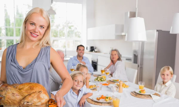 Blonde woman showing the roast turkey — Stock Photo, Image