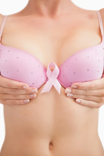 Kvinna med bröst cancer awareness ribbon bifogas BH — Stockfoto