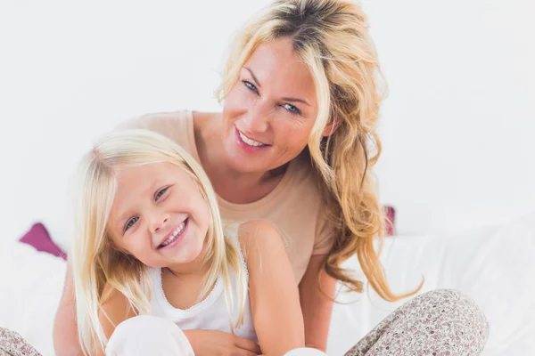 Madre y su hija sentadas en una cama — Foto de Stock