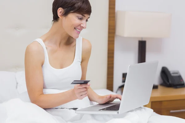 Vrouw online winkelen in bed — Stockfoto