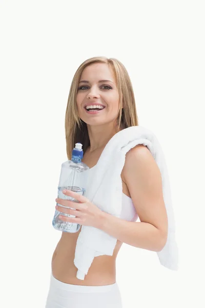 Retrato de mulher feliz com toalha segurando garrafa de água — Fotografia de Stock