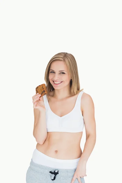 Portrait of happy young woman holding cookie — Stock Photo, Image